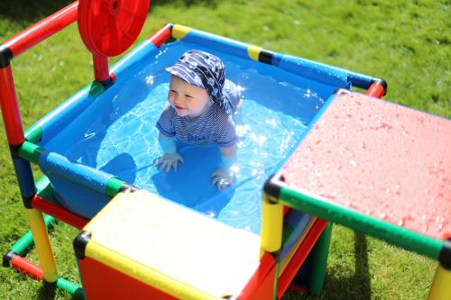 Niño en juego de trepa con piscina