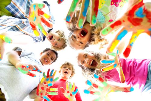 Dzieci pokazują dłonie pomalowane na różne kolory