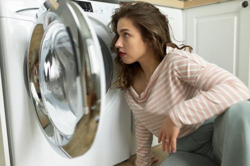Kobieta siedząca przed pralką