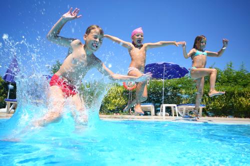Dzieci skaczące z brzegu basenu