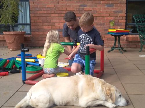 Children building with QUADRO with their father