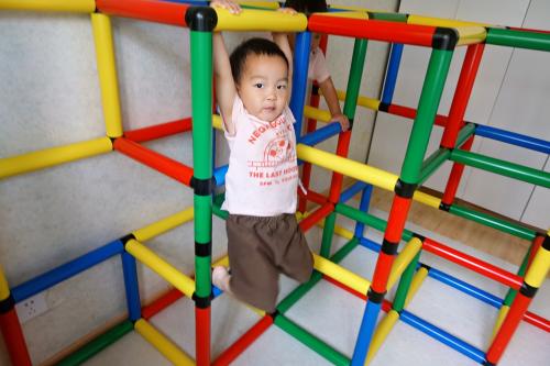 Boy hanging on a jungle gym